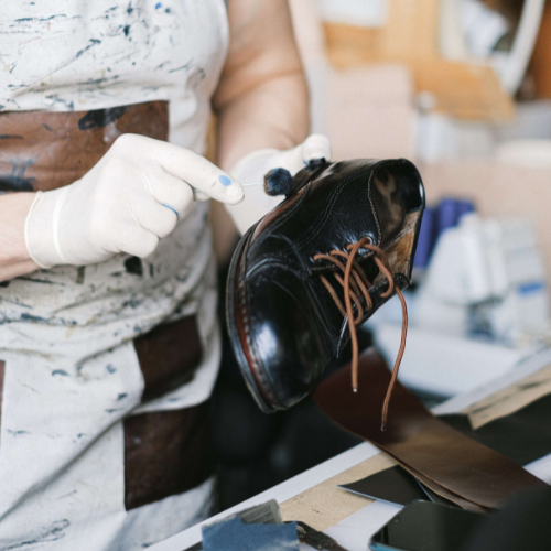 Woman polishing a shoe with a leather brush